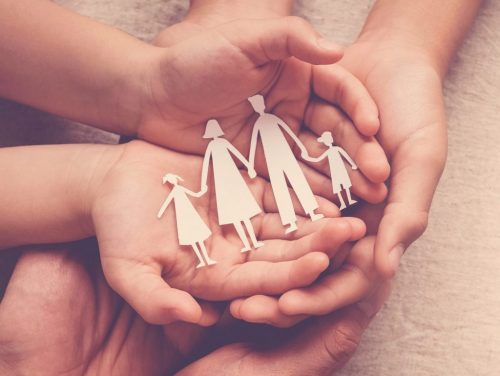 hands holding paper family cutout, family home, adoption foster care, homeless support , mental health, homeschooling , cost of living during recession concept